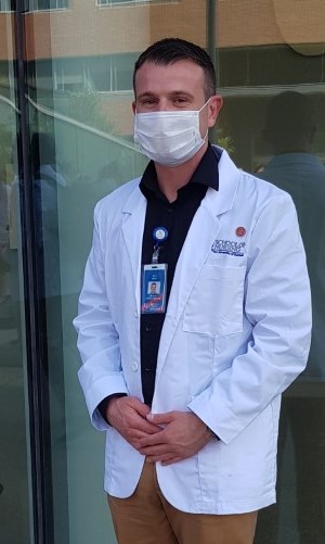 Salter wearing mask and white coat outside HEB