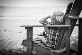 Young boy sitting on a chair holding a fishing pole