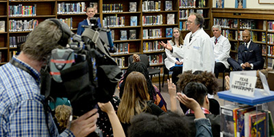 Dr. Salathe speaking with students and videocamera in foreground